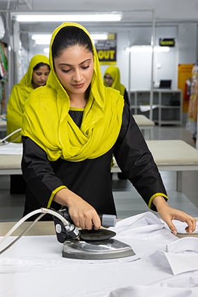 Worker ironing a shirt at Jab Chaho.