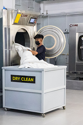 Workers handling washing and dry cleaning in an industrial facility.